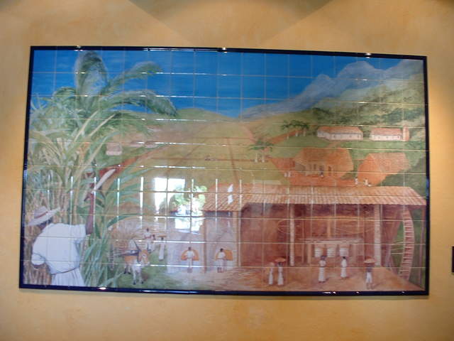 Hand painted tile depicting the workers of the rum industry